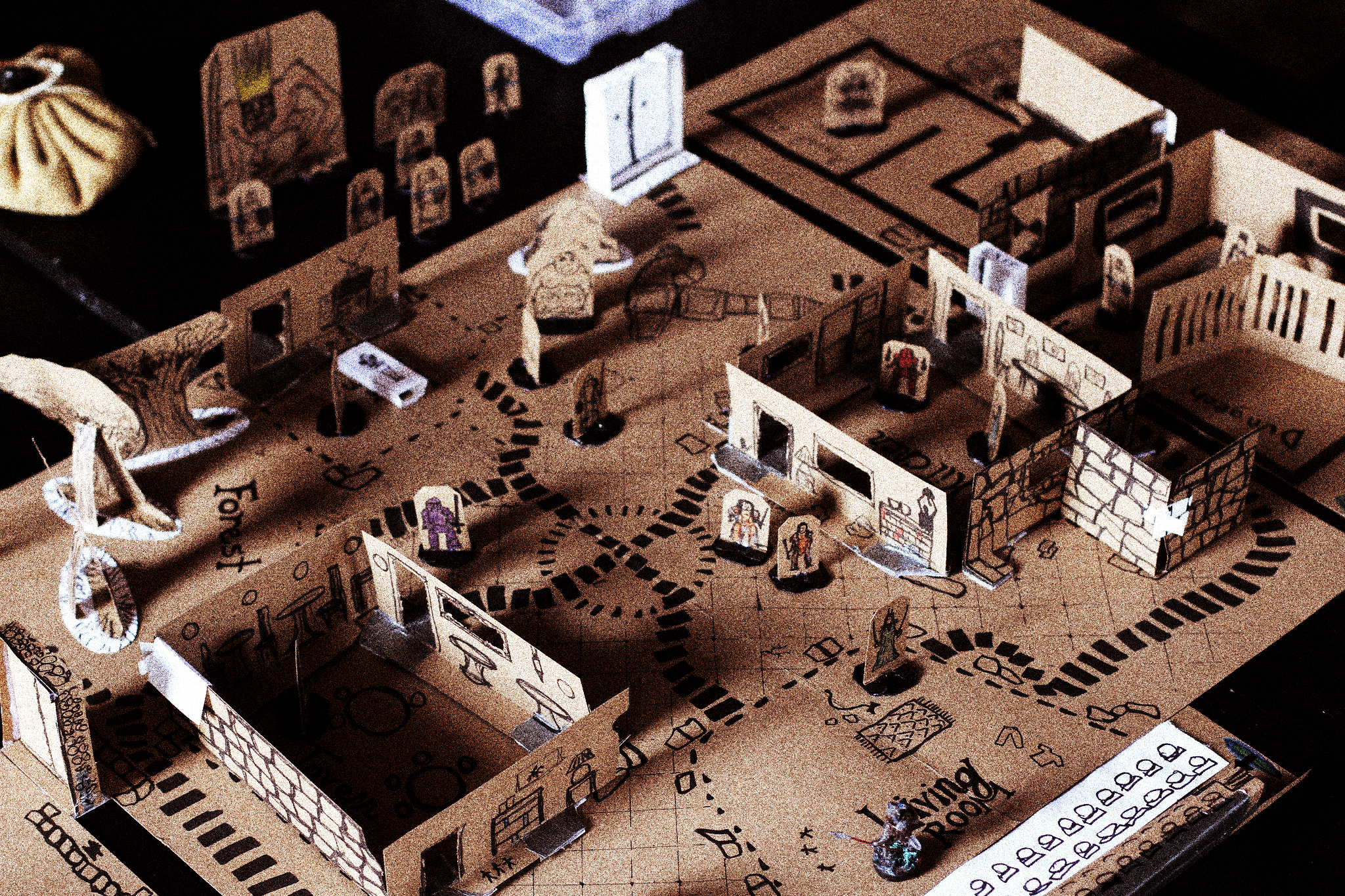 A game board, with pathways, rooms, and small figurines made entirely out of cardboard.